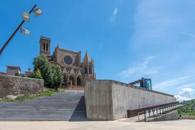 a church with a staircase in front of a building at Kisa Apartments de Manresa in Manresa