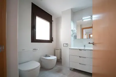 a bathroom with a toilet and a sink and a mirror at Kisa Apartments de Manresa in Manresa