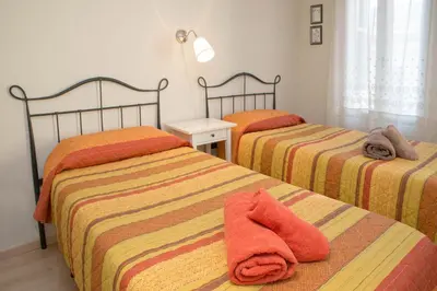 a bedroom with two beds with orange and yellow sheets at Barcelona4Seasons - Gavina in Barcelona