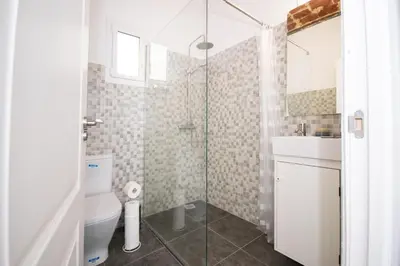 a bathroom with a shower and a toilet and a sink at Apartahotel Casa Batito in Hospitalet de Llobregat