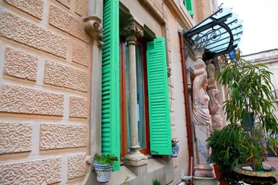 a window with green shutters on a building at Sitges Royal Rooms in Sitges