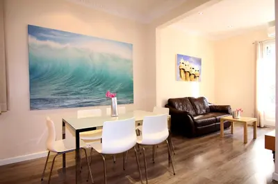 a living room with a table and chairs and a couch at ClassBedroom Eixample Free Apartments in Barcelona