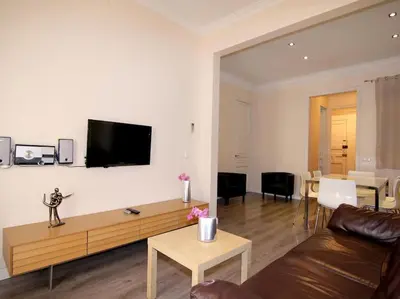 a living room with a couch and a tv on a wall at ClassBedroom Eixample Free Apartments in Barcelona