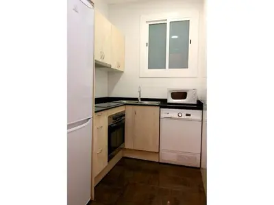 a kitchen with a white refrigerator and a dishwasher at ClassBedroom Eixample Free Apartments in Barcelona