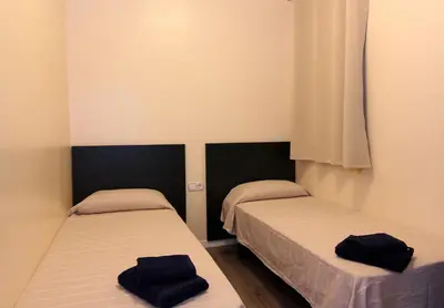 two beds in a small room with black towels on them at ClassBedroom Gaudí Apartments in Barcelona