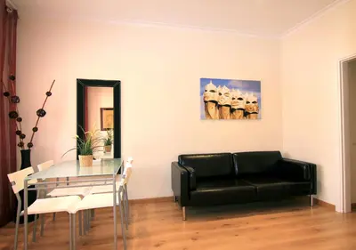 a living room with a black couch and a glass table at ClassBedroom Gaudí Apartments in Barcelona