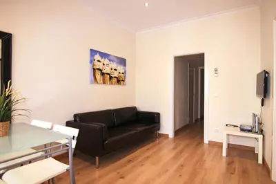 a living room with a couch and a painting on the wall at ClassBedroom Gaudí Apartments in Barcelona