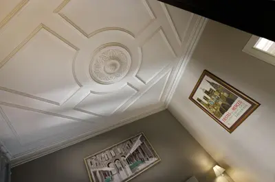 a white coffered ceiling in a room with two pictures at Enjoy Apartments Gran Via in Barcelona
