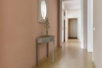 a hallway with a table and a mirror on a wall at Enjoy Apartments Gran Via in Barcelona