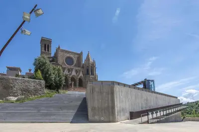 a building with a staircase leading to a church at Apartamento Arbones de Manresa in Manresa