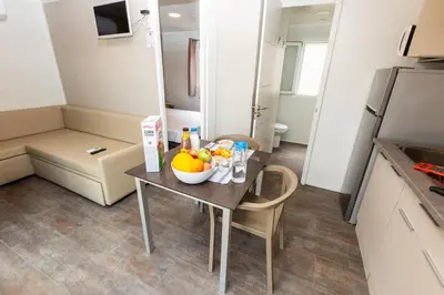a room with a table with a bowl of fruit on it at Camping Bellsol Pets in Pineda de Mar