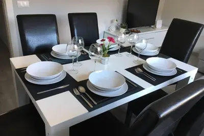 a white table with chairs and plates and wine glasses at sagrada familia gaudi in Barcelona