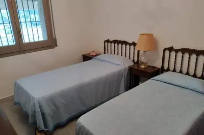 a bedroom with two beds and a table with a lamp at Masia Can Castanyola in Marganell