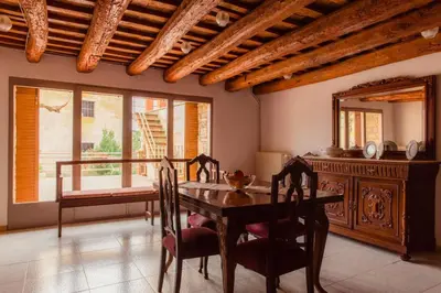 a dining room with a table and chairs and a mirror at Masia Can Castanyola in Marganell
