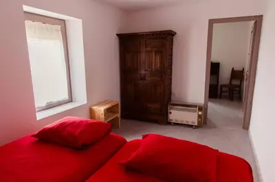 a bedroom with a red bed and a mirror at Masia Can Castanyola in Marganell