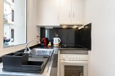 a kitchen with white cabinets and a sink at Lodging Apartments Beach Studio 11 in Barcelona