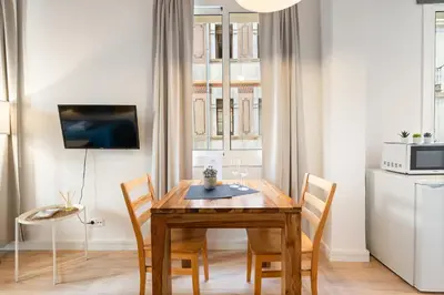 a dining room with a wooden table and chairs at Lodging Apartments Beach Studio 11 in Barcelona