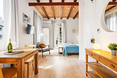 a living room with a table and a couch at Lodging Apartments Beach Studio 22 in Barcelona