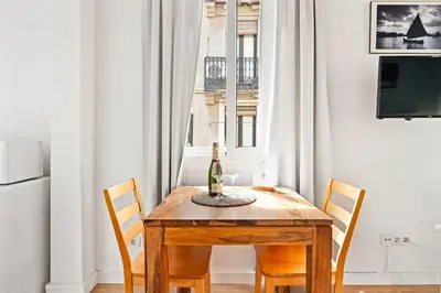 a dining room table with a bottle of wine on it at Lodging Apartments Beach Studio 22 in Barcelona
