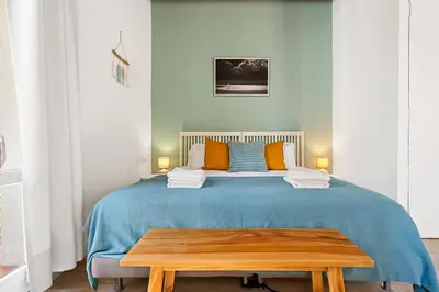 a bedroom with a blue bed with a wooden table at Lodging Apartments Beach Studio 22 in Barcelona