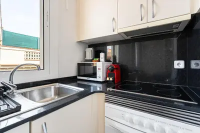 a kitchen with a sink and a microwave at Lodging Apartments Beach Studio 41 in Barcelona