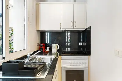 a kitchen with white cabinets and a sink at Lodging Apartments Beach Studio P1 in Barcelona
