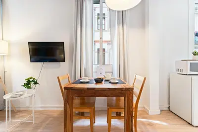 a dining room with a wooden table and chairs at Lodging Apartments Beach Studio P1 in Barcelona