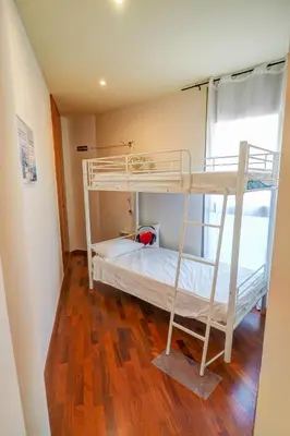 a bedroom with two bunk beds and a wooden floor at Seaside April Apartment by Hello Homes Sitges in Sitges