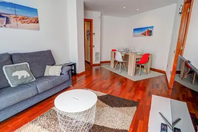 a living room with a couch and a table at Seaside April Apartment by Hello Homes Sitges in Sitges