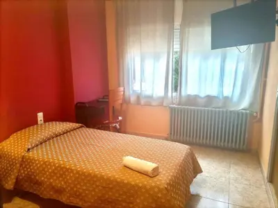 a bedroom with a bed with a towel on it at Hostal Isla Cristina Mataro in Mataró