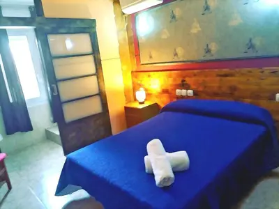 a bedroom with a blue bed with a towel on it at Hostal Isla Cristina Mataro in Mataró