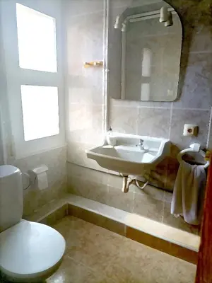 a bathroom with a sink and a toilet and a mirror at Hostal Isla Cristina Mataro in Mataró