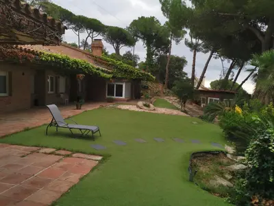 a bench sitting in the yard of a house at Villa Maresme & Villa Rosa in Mataró