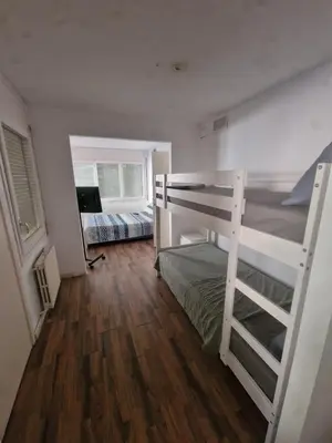 a bedroom with two bunk beds and a wooden floor at Villa Maresme & Villa Rosa in Mataró