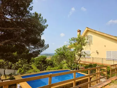 a house with a swimming pool and a wooden fence at Villa Maresme & Villa Rosa in Mataró