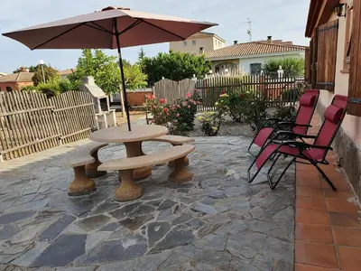 a picnic table and an umbrella on a patio at Vino que del Cielo Vino. Alt Penedès (País del Cava) Barcelona in San Quintín de Mediona