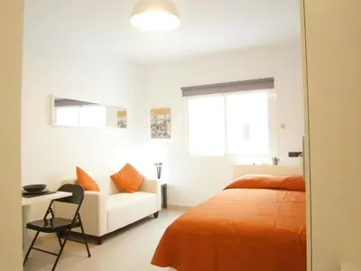 a white bedroom with a bed and a white couch at Marbel Apartments in Barcelona