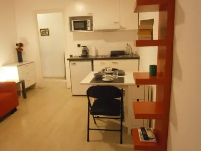 a small kitchen with a table and a chair at Marbel Apartments in Barcelona