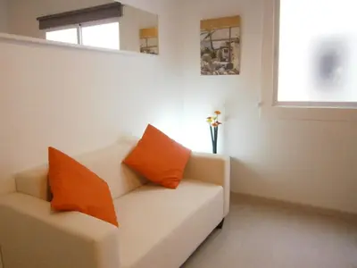 two orange pillows on a white couch in a room at Marbel Apartments in Barcelona