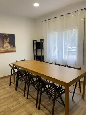 a large wooden table with chairs and a window at Apartamentos Tarradellas Sants Estació in Barcelona
