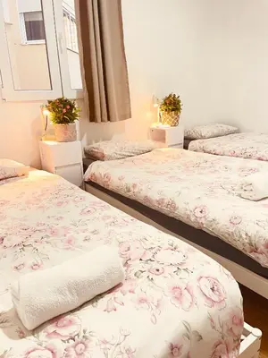 three beds in a room with pink flowers at Apartamentos Tarradellas Sants Estació in Barcelona