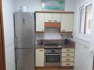 a kitchen with a refrigerator and a stove at APARTAMENTO CON OFICINA Y VISTAS AL MAR in Sitges