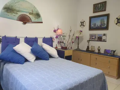 a bedroom with a blue bed with blue and white pillows at APARTAMENTO CON OFICINA Y VISTAS AL MAR in Sitges