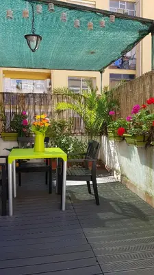 a green table and bench on a patio with flowers at Estudio Maignon in Barcelona
