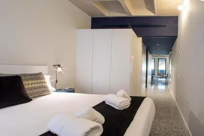 a bedroom with a large white bed with towels on it at Barcelona Touch Apartments - Rosich in Hospitalet de Llobregat