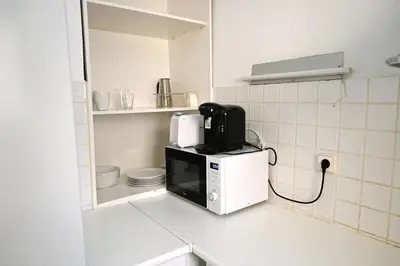 a microwave sitting on top of a counter in a kitchen at Homenfun Barcelona Gracia in Barcelona