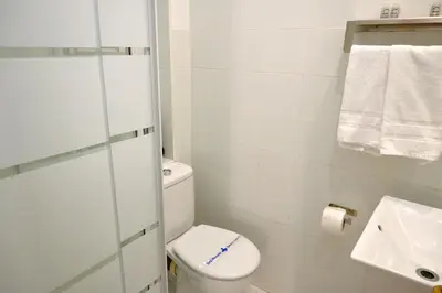 a white bathroom with a toilet and a sink at Homenfun Barcelona Gracia in Barcelona