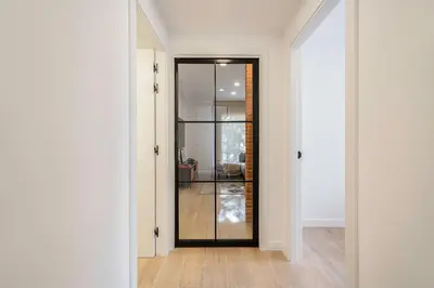 a hallway with a glass door leading into a living room at ApartsNouBcn Equador Les Corts in Barcelona