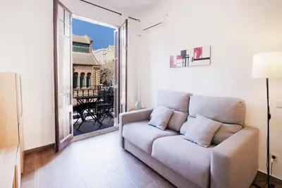 a living room with a couch and a large window at Mirall Sant Gervasi in Barcelona