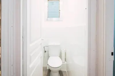 a white toilet in a white bathroom with a window at Mirall Sant Gervasi in Barcelona